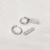 Verticaal ovaal gevormde bedeloorbel met peace hart en smiley symbool