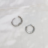 een centimeter diameter makkelijk te sluiten oorringen gemaakt van staal ingelegd met zes kristallen