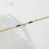 Klassieke figaro schakelarmband met 6 kleine zwarte steentjes met gouden muntje