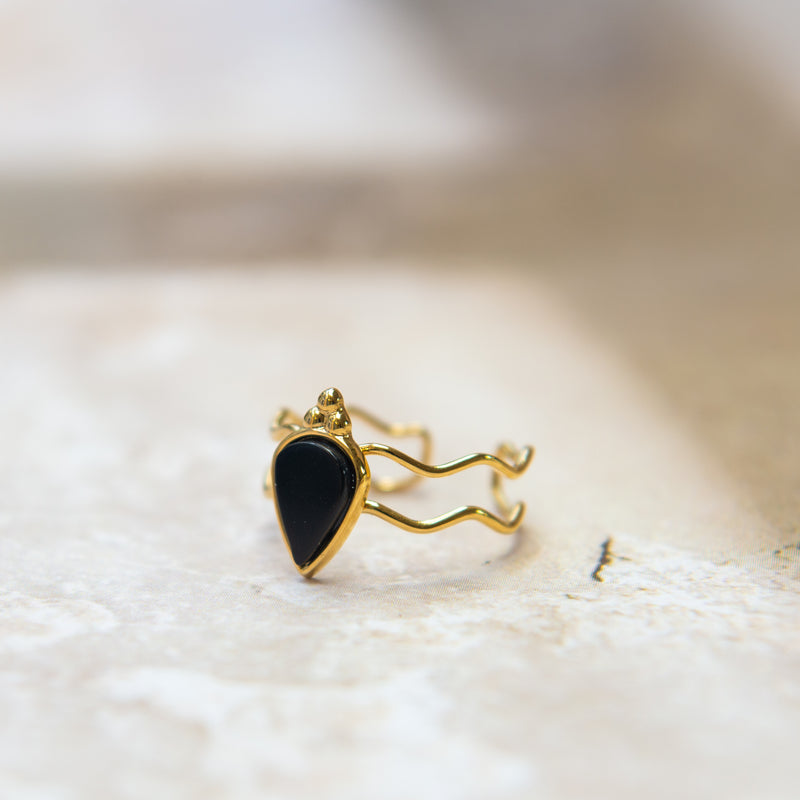 Gouden gewoven ring met een druppelvormige zwarte steen 